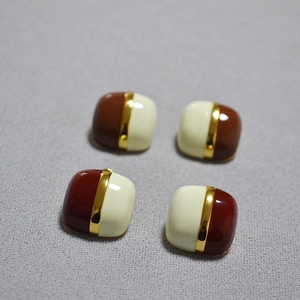 Macro view of geometric square stud earrings with enamel contrast and gold plating finish