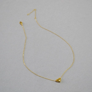 Vue détaillée du pendentif cœur doré avec une chaîne réglable à fermoir mousqueton