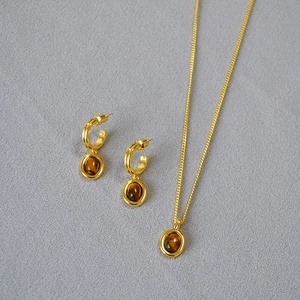 Detailed view of vintage gold-plated necklace and tiger eye stone earrings set