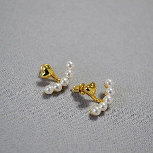 Close-up of elegant gold heart earrings with curved pearl drop design and 925 silver needle