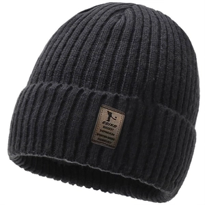 Close-up of black ribbed knit beanie with brown leather EDIKO label and warm lining