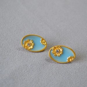 Oval gold-plated stud earrings with blue enamel and daisy floral patterns