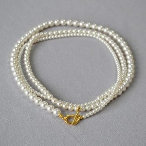 Detailed view of elegant multi-layer pearl necklace with golden OT clasp closure