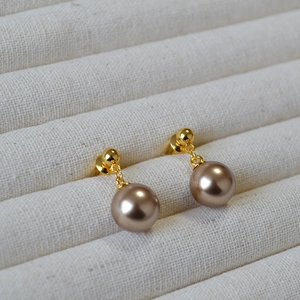 Elegant champagne pearl drop earrings with gold studs on a premium fabric display box