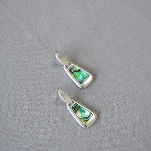 Geometric silver earrings with colorful abalone shell inlays in a minimalist trapezoid style