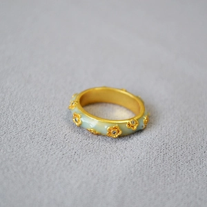 Macro view of vintage gold-plated flower ring with mint green enamel and zircon stones