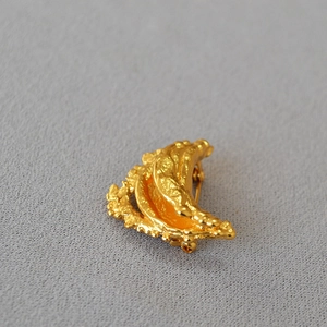 Detail showing the lava texture and irregular moon shape of the gold-plated brass brooch