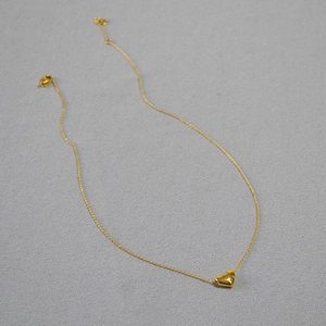 Gros plan du collier avec pendentif cœur texturé doré et fermoir mousqueton robuste