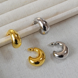 Polierte goldene und silberne klobige Teardrop-Ohrringe auf einer Schmuckschatulle