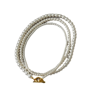 Three-layer creamy white pearl necklace featuring a golden lava texture OT toggle clasp