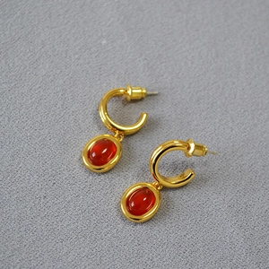 Detail von vergoldeten C-Messingohrringen im Vintage-Stil mit ovalen roten Achatsteinen