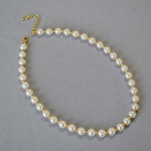 Detail of high-gloss pearls and gold spacer beads on an elegant minimalist necklace