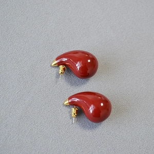 Detailed shot of red teardrop enamel earrings with gold-plated sterling silver pins