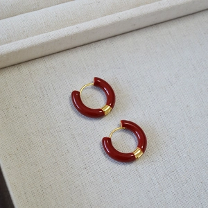 Boucles d'oreilles rétro en émail rouge et laiton doré présentées sur un plateau