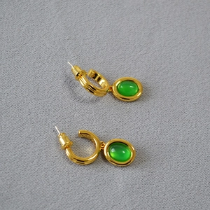 Details von Vintage-Ohrringen aus Messing mit Vergoldung und ovalen grünen Edelsteinen