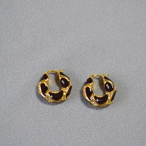 Macro detail of French vintage gold hoop earrings with burgundy enamel and micro zircons