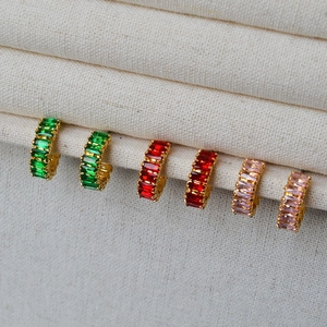 Détail de créoles dorées serties de zircons cubiques baguettes verts, rouges et roses