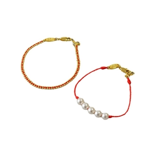 Handcrafted red string bracelets with pearls and gold chain links on white background