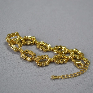 Detail of gold beaded bracelet featuring faceted laser beads and adjustable lobster clasp