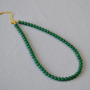 Detail of green agate beaded necklace with gold lobster clasp and extension chain