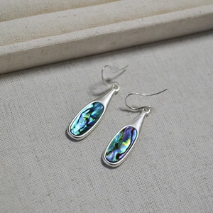 Macro shot of silver drop earrings featuring iridescent colorful abalone shell inlays
