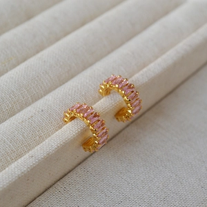 Vue détaillée des boucles d'oreilles en C dorées avec zircons roses rectangulaires