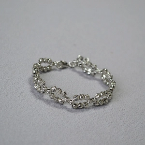 Detailed view of dual-row woven laser-cut silver beads bracelet with sparkling facets