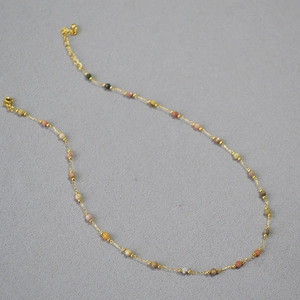 Détail du collier doré avec pierres naturelles colorées et fermoir mousqueton ajustable