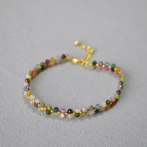 Detail eines bunten Turmalin-Perlenarmbands mit goldenen Zwischenperlen und Verschluss