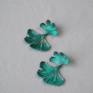 Macro detail of vintage ginkgo leaf earrings with aged green finish and leaf vein texture