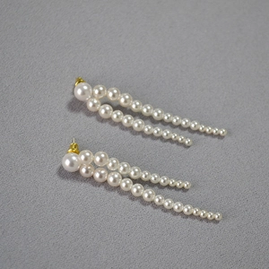Détail de boucles d'oreilles à pampilles en perles avec tiges dorées et perles dégradées