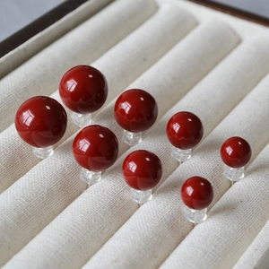 Boucles d'oreilles en émail rouge cerise de tailles variées sur plateau en velours