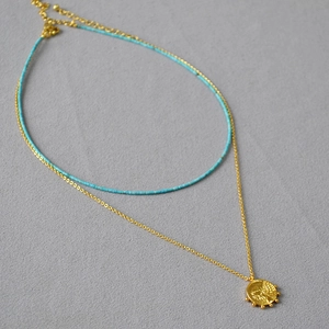 Détails du collier à perles turquoise et pendentif pièce de monnaie dorée vintage