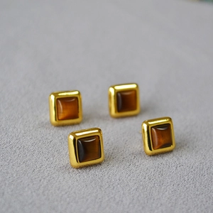 Vue détaillée de boucles d'oreilles carrées en oeil de tigre avec monture dorée