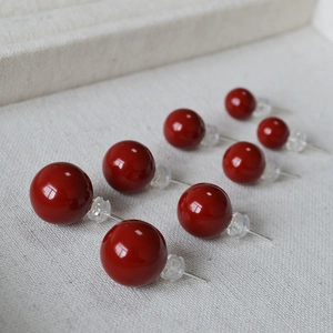 Détail de quatre paires de boucles d'oreilles rondes en émail rouge cerise avec tiges en argent