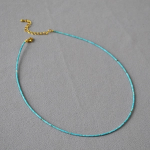 Détail du collier de perles turquoise avec fermoir mousqueton doré et extension