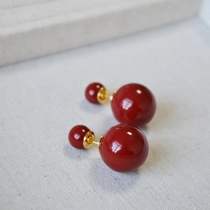 Detailed macro shot of vintage burgundy double pearl earrings with gold-tone hardware