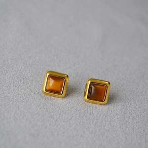Vue détaillée de boucles d'oreilles carrées en oeil de tigre avec serti doré