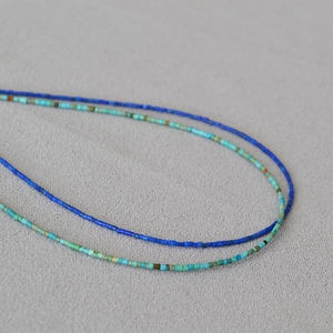 Macro detail of fine handmade beaded necklace with turquoise and blue cylinder beads