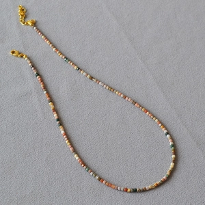 Detail of square-cut natural stone necklace with gold lobster clasp and adjustable chain