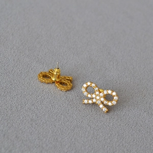 Detail of gold bow earrings with pavé zircons showing front design and pin structure