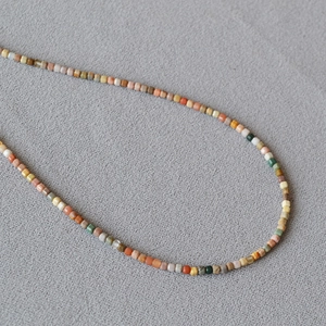 Macro detail of natural stone cubic beads in retro earth tones for clavicle necklace