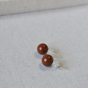 Détail de boucles d'oreilles rondes en émail rouge cerise avec tiges en argent 925 et silicone