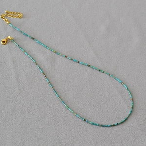 Detail of colorful beaded choker with turquoise beads and gold lobster clasp closure