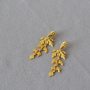 Vintage textured golden leaf drop earrings with sparkling zircon accents on grey background