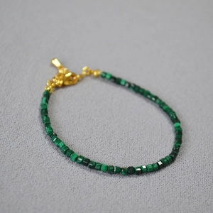Dettaglio del bracciale con perline di malachite quadrate con chiusura dorata