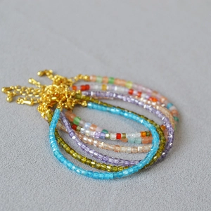 Macro detail of multi-colored square crystal beads with adjustable golden lobster clasp