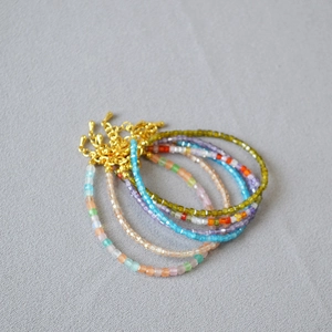 Close-up of colorful square bead bracelets with golden adjustable lobster clasp chains