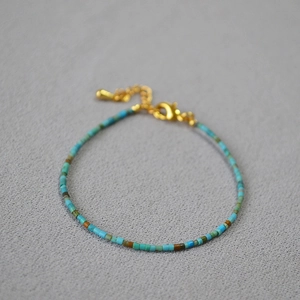 Detail of bohemian beaded bracelet with turquoise stones and gold adjustable lobster clasp