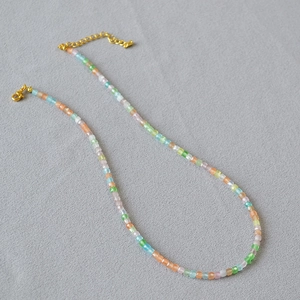 Macro view of multi-colored translucent square crystal beads with gold lobster clasp